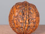 a walnut on a wooden table with a gray wall in the background