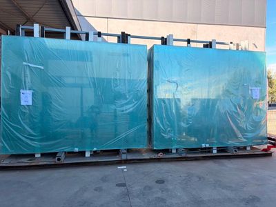 deux grands panneaux en plastique bleu posés sur une palette devant un bâtiment
