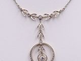 a close up of a necklace with a circular pendant on a chain