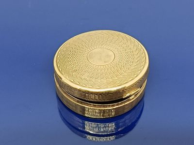 une image représentant un pilulier plaqué or sur un fond bleu
