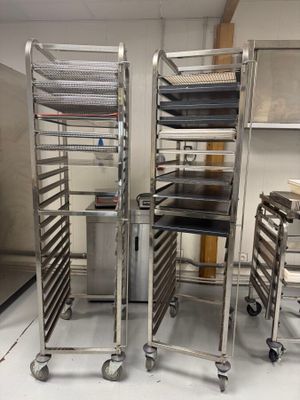 Plusieurs plateaux de nourriture sont empilés les uns sur les autres dans une cuisine