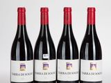 trois bouteilles de vin rouge sont alignées sur une surface blanche
