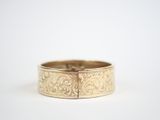 a close up of a gold ring on a white surface
