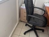 a black office chair sitting in front of a window