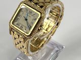 an image of a gold wrist watch on a clear stand