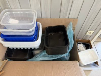 a cardboard box filled with plastic containers and plastic containers