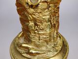 gold plated figurine of a man with a basket of bread