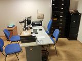 a desk with several chairs and a computer on top of it
