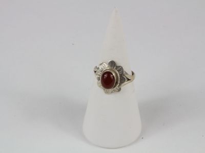 a close up of a ring with a red stone on it