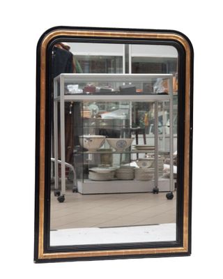 un grand miroir avec un cadre noir accroché au mur
