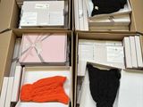 Plusieurs cartons de vêtements sont empilés les uns sur les autres sur une table