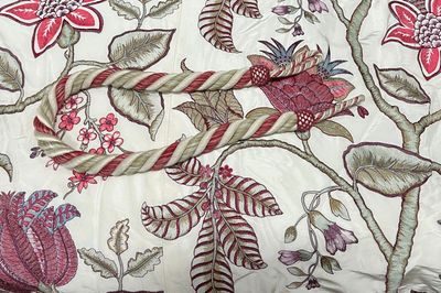 a close up of a bed with a floral design on it
