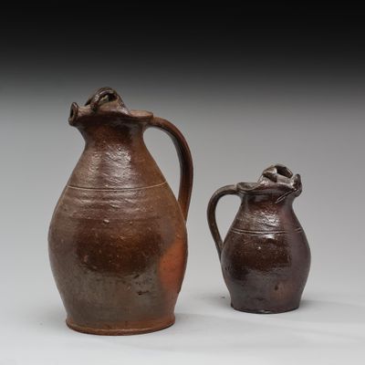 deux vases bruns posés l'un à côté de l'autre sur une surface blanche