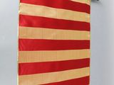 un drapeau rouge et or accroché au mur d'une pièce