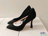 pair of black high heeled shoes with a wooden stick sticking out of the heel