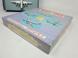 a blue suitcase with a book on it next to a toy airplane