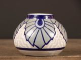 un vase bleu et blanc posé sur une table en bois
