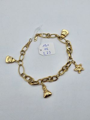 a gold charm bracelet with bells and charms on it