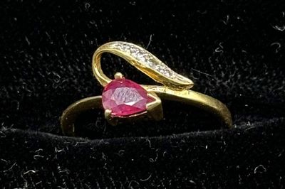 an image of a gold ring with a heart shaped ruby stone