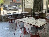 tables and chairs in a restaurant with a view of the street