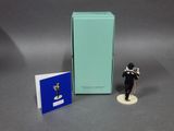 a figurine of a man holding a book next to a box