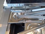 stainless steel pans and tongs are sitting in the bottom of a stove