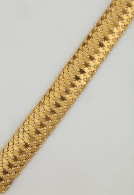 gros plan d'un bracelet en or sur une surface blanche