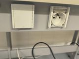 wires are plugged into a wall mounted outlet on a table