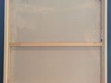 an empty picture frame sitting on top of a wooden table next to a blue wall
