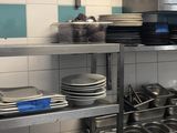 beaucoup d'assiettes et de casseroles sur les étagères de la cuisine
