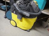 a yellow and black vacuum sitting on top of a yellow cart