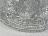 a glass tray with a pitcher and glasses on it