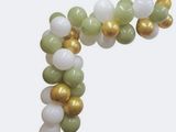 a balloon arch made of green, white and gold balloons