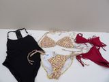 three swimsuits are laid out on a table with a price tag
