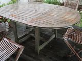 a wooden table and four chairs on a wooden deck