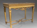an antique console table with gold leaf decoration and glass top