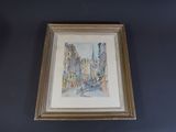 painting of a street scene in a gold frame on a blue wall