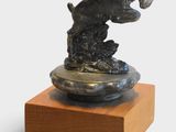 statue of a dog on a wooden base on a white background