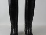 a pair of black leather riding boots on a white surface
