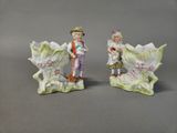 pair of porcelain figurines of a boy and a girl with flowers