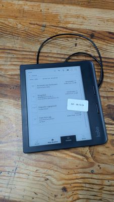 un Kindle posé sur la table, avec un mot accroché dessus