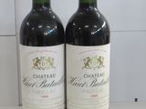two bottles of wine sitting next to each other on a counter