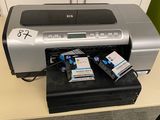 a printer sitting on top of a desk next to a cell phone