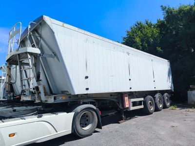 un gros camion blanc garé sur le parking