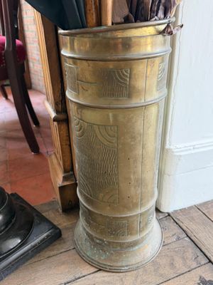 un grand vase contenant des parapluies, posé par terre