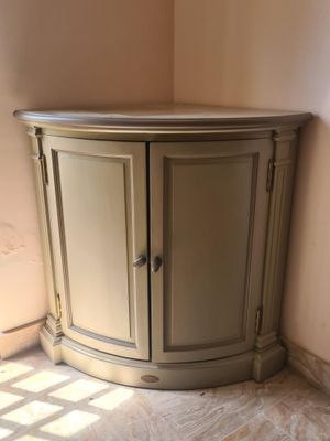 une armoire d'angle placée dans un coin de la pièce