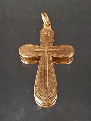 croix plaquée or sur une surface noire avec un fond noir