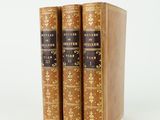 trois livres superposés sur une surface blanche