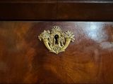 a wooden chest of drawers with a brass knob on it