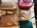 many purses on a table with price tags on them